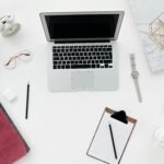 A clean, minimal workspace setup for digital marketers and online business owners, featuring a laptop, notebook, and productivity essentials to help you plan smarter, stay organized, and grow faster.
