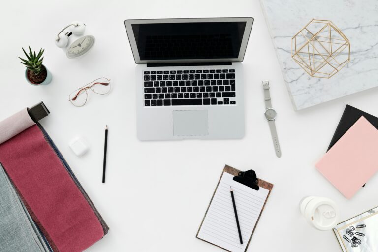 A clean, minimal workspace setup for digital marketers and online business owners, featuring a laptop, notebook, and productivity essentials to help you plan smarter, stay organized, and grow faster.