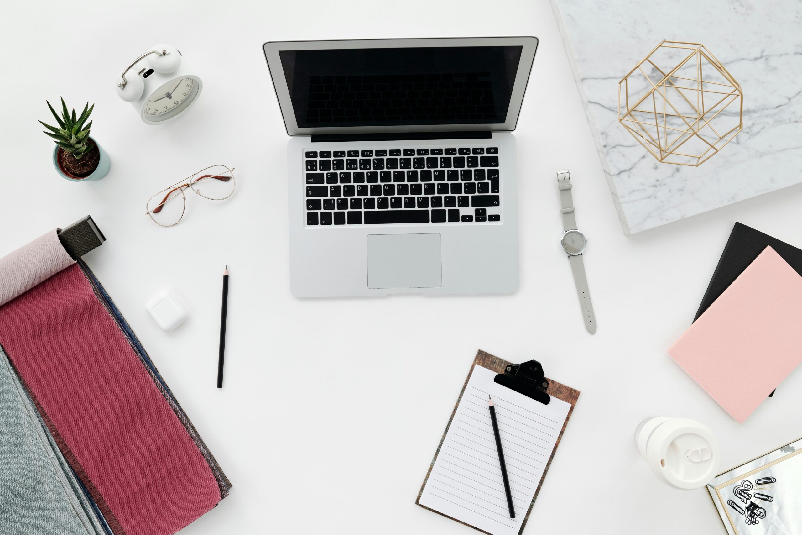 A clean, minimal workspace setup for digital marketers and online business owners, featuring a laptop, notebook, and productivity essentials to help you plan smarter, stay organized, and grow faster.